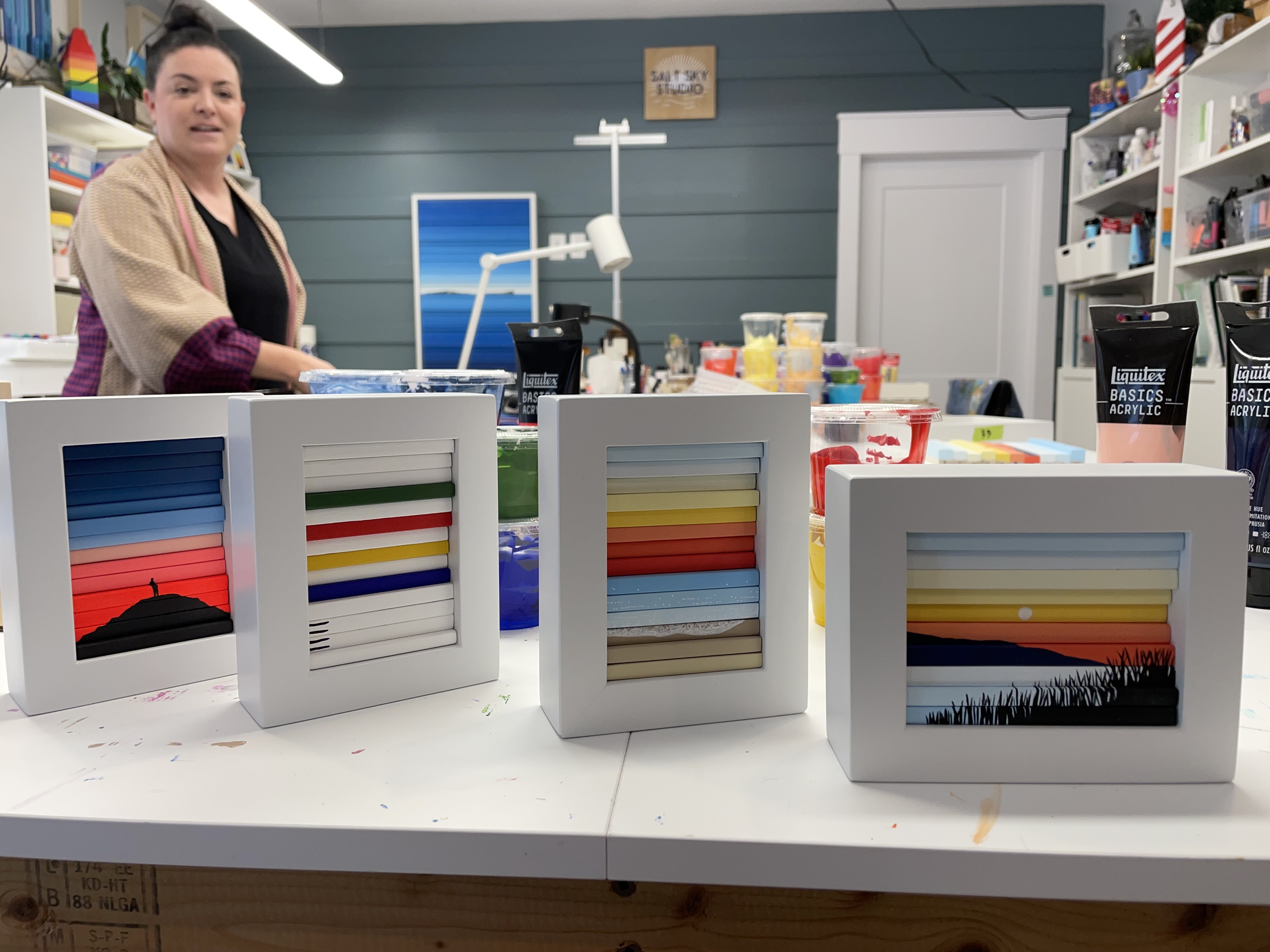 Photo of four mini wood slat artworks showing bright colours and beach landscapes